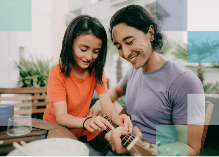 Father and daughter play the guitar after finding a vision product solution