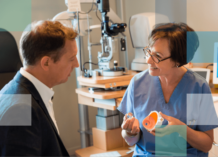 Eye Care Professional holding a three dimensional model of an eye explaining to a patient