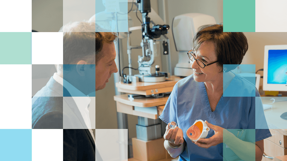 Eye Care Professional holding a three dimensional model of an eye explaining to a patient