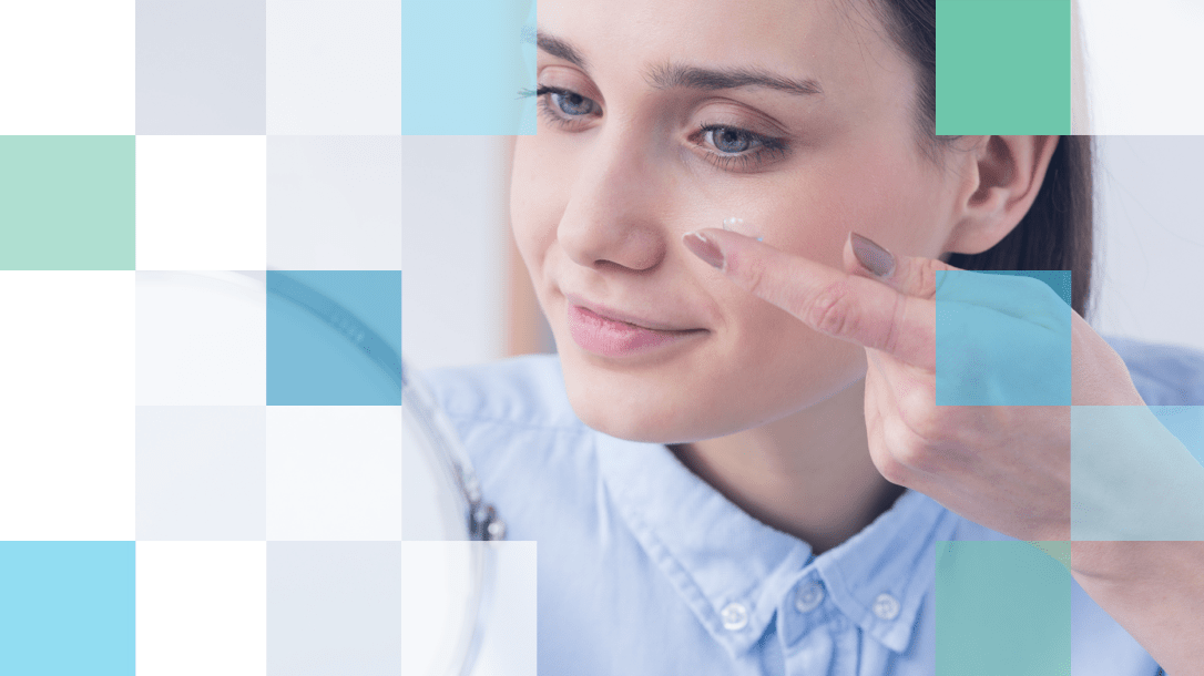 Blue eyed woman putting contact lens in left eye