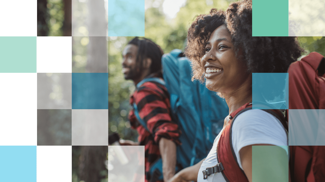 Couple going for a hike with backpacks on smiling