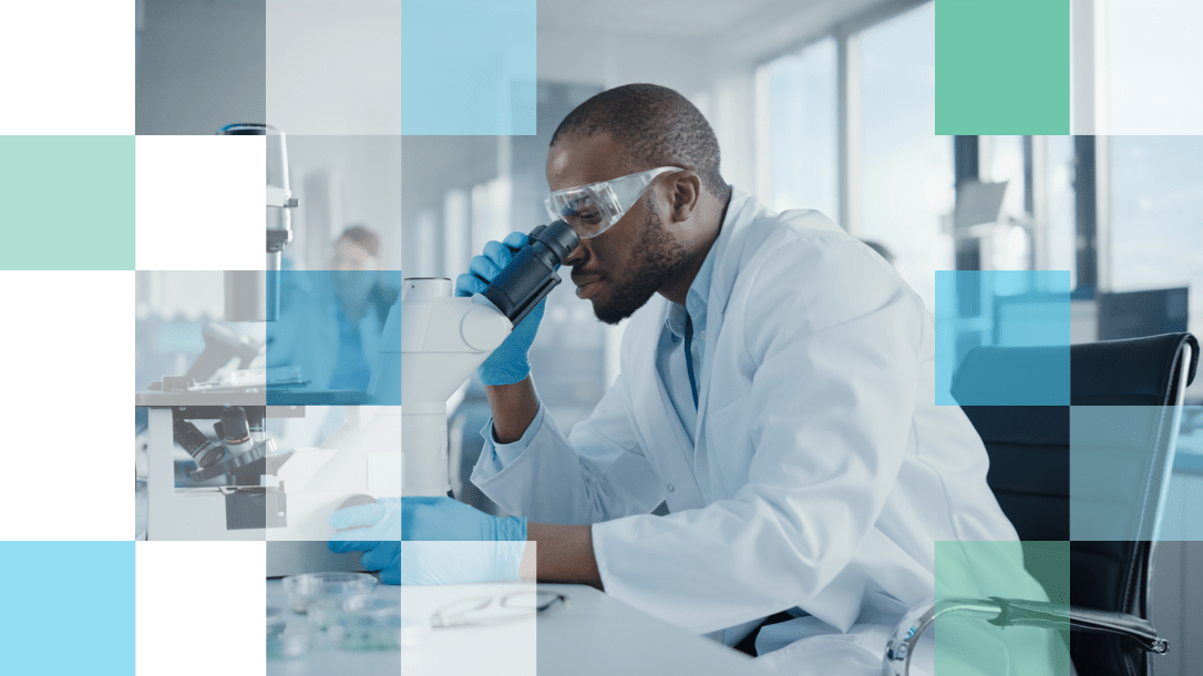 Eye Care Professional in laboratory looking through a microscope at a sample