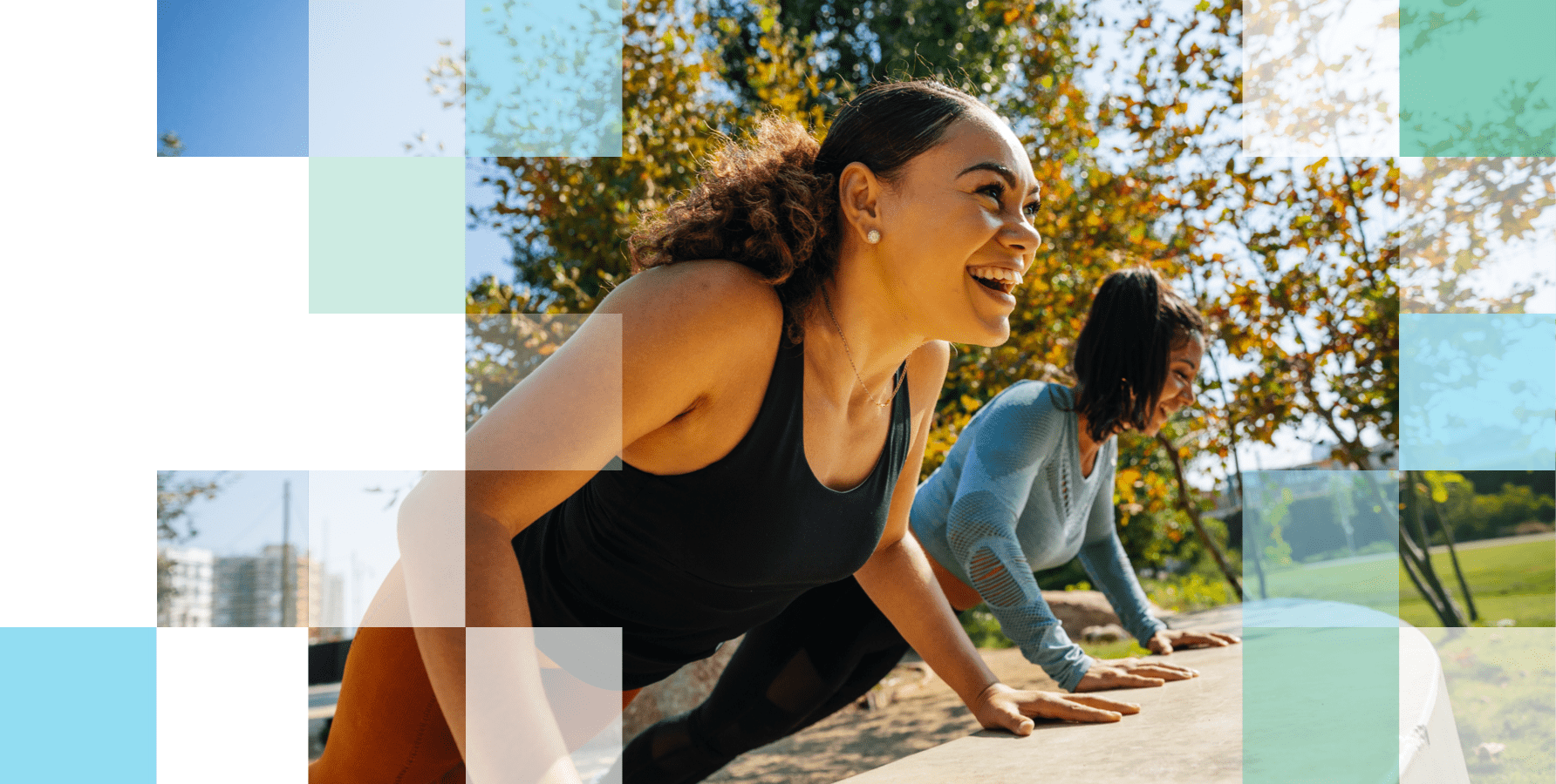 Two women doing exercise in a park smiling